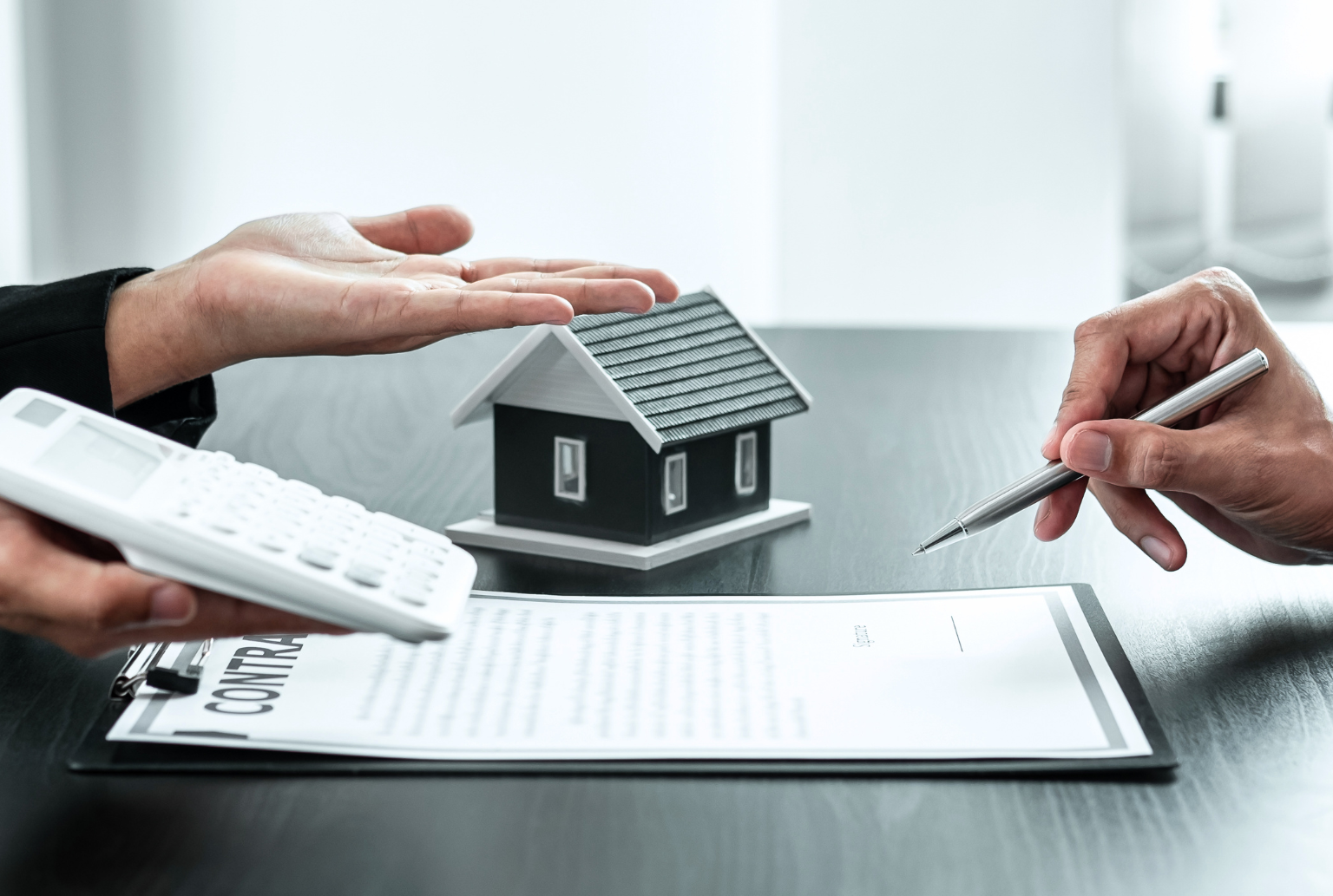closeup hands holding calculator and pen signing a contract