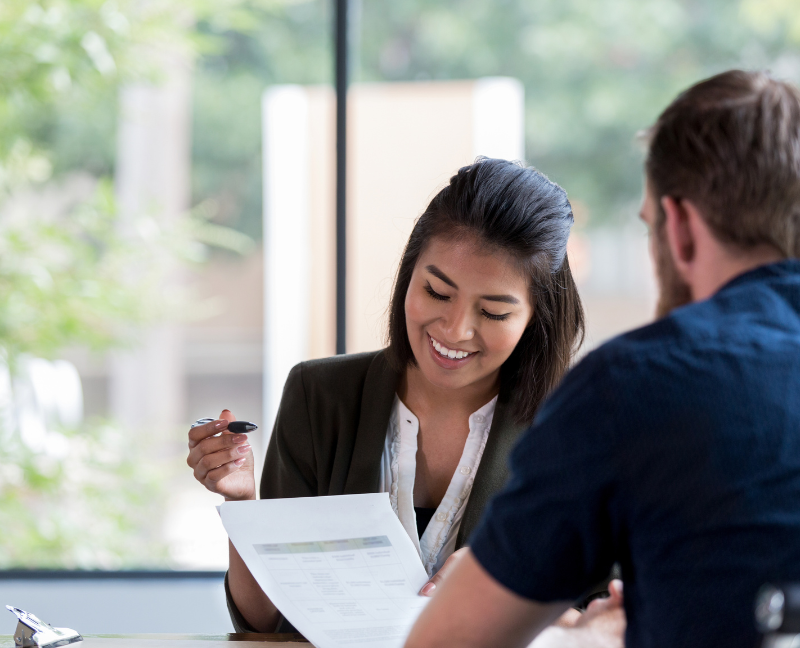 agent holding pen asking home buyer to sign up loan agreement