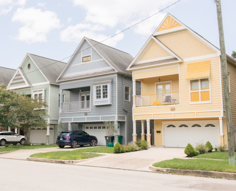 three houses in peaceful neighborhood with car