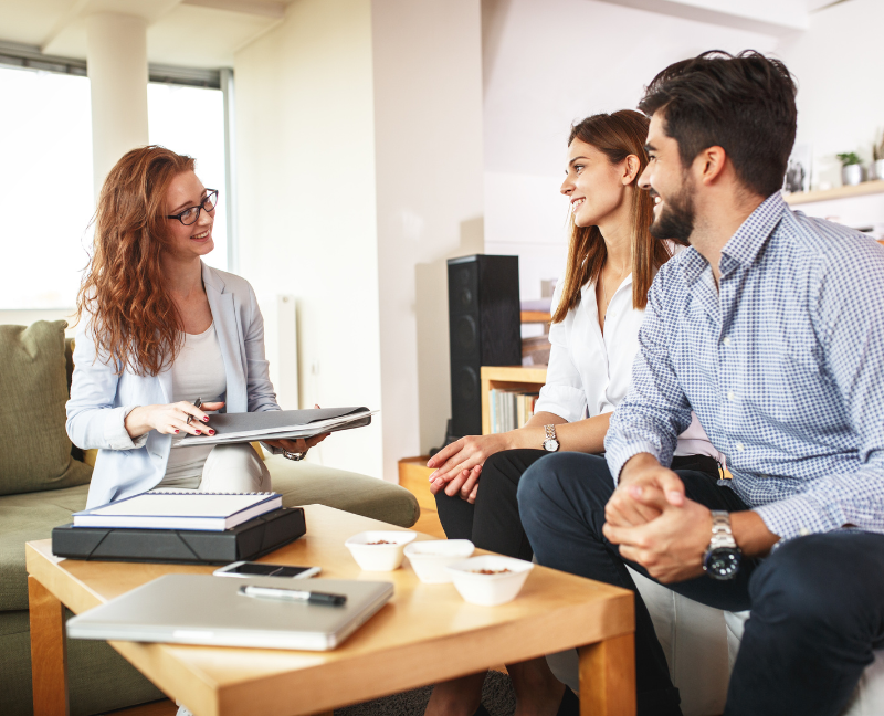 real estate agent talking to couple about a house