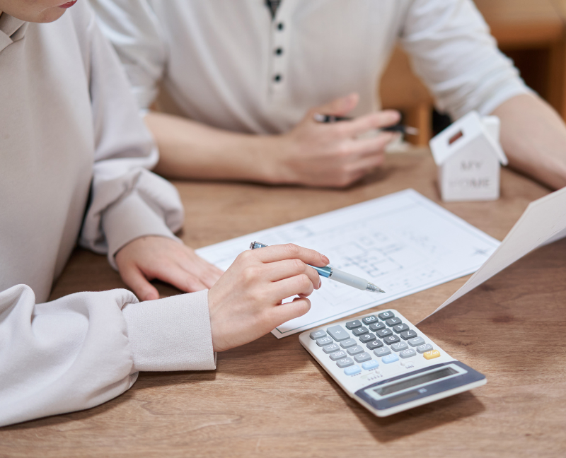 title agent holding pen and calculator