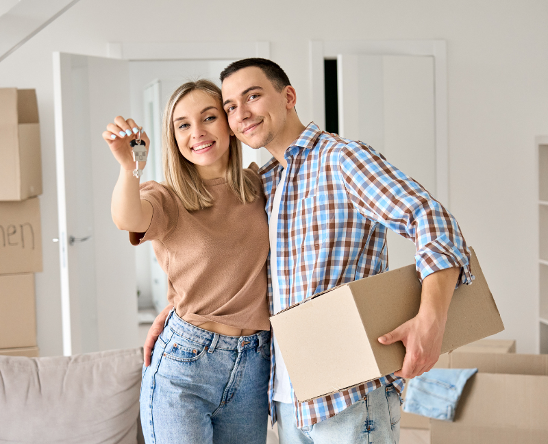 young couple holding keys to new house