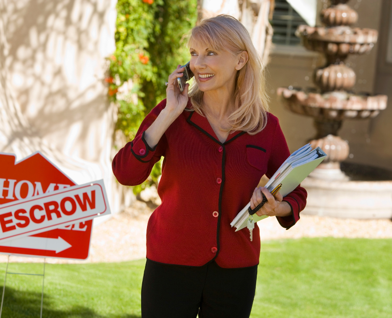 agent answering a phone call while holding some documents