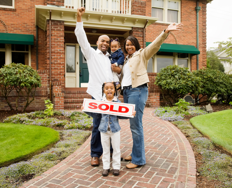 family holding sold sign at new home
