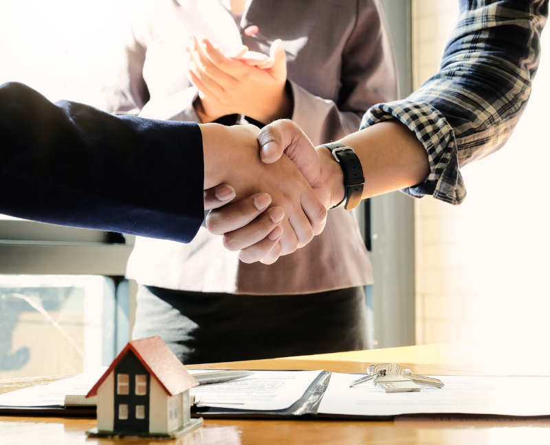 real estate agent shaking homebuyers hand