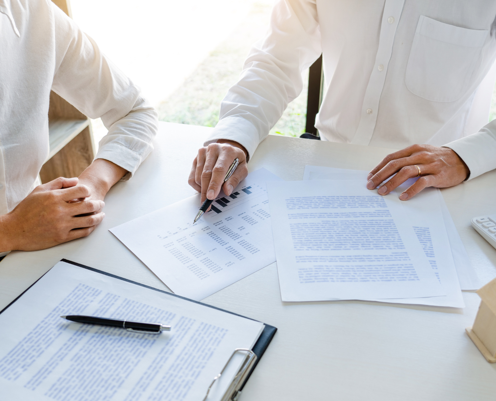 real estate agents holding pen and signing contracts