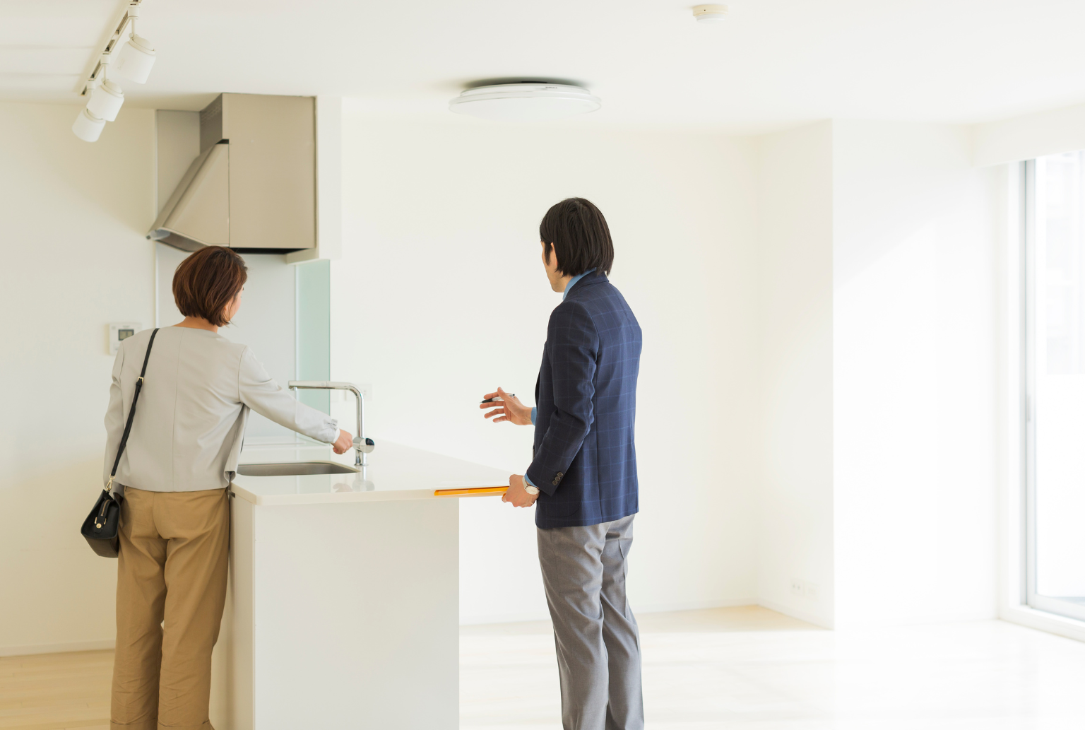 woman checking sink of rental property with agent