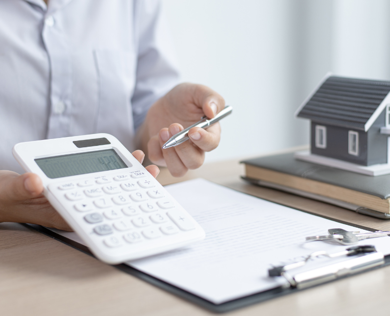 agent holding calculator and pen for mortgage