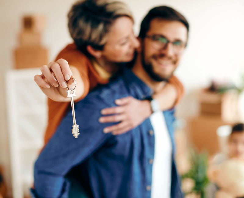 couple owning new home holding key