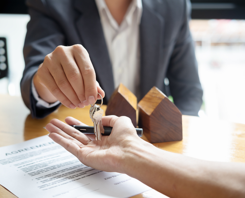 real estate agent handing keys to homeowner